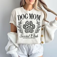 a woman wearing a dog mom t - shirt with her hands in her pockets and the words social club on it