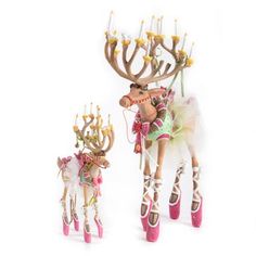 two deer figurines are standing next to each other with candles in their mouths