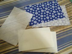 several pieces of paper laid out on a striped tablecloth with blue and white flowers