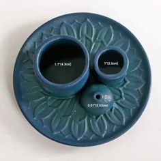 two blue vases sitting on top of a plate