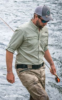 a man standing in the water with a fishing rod