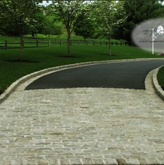 a paved road with trees and bushes in the background