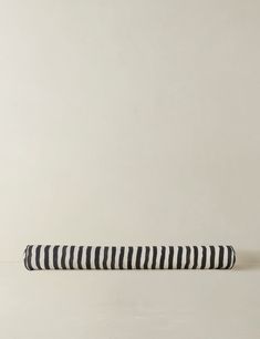 a black and white striped pillow sitting on top of a table