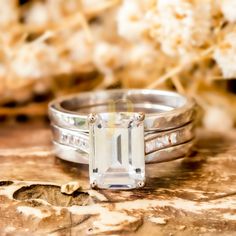 two wedding rings with an emerald cut diamond