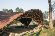 an outdoor stage with seating and trees in the background