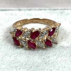 This ring has 2 tiny natural diamonds but gives the illusion of having 8! The 6 marquise cut simulated rubies have a beautiful red color and measure 4.6x2.3mm, totaling well over 3/4 carats. This is a great ring to wear on vacations when you want to leave the real thing at home! Size 7.75 Shank is 2.6mm Marquise Red Diamond Ring, Marquise Ruby Jewelry With Diamond Accents, Red Marquise Diamond Ring Fine Jewelry, Red Marquise Rings With Diamond Accents, Red Marquise Ring With Diamond Accents, Red Marquise Diamond Accent Rings, Red Ruby Ring With Marquise Cut Diamond, Marquise Ruby Ring With Diamond Accents, Red Marquise Cut Diamond Ring