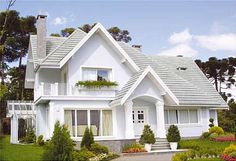 a large white house sitting on top of a lush green field