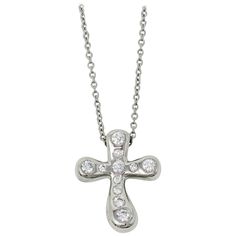 Simply stunning modernized diamond cross pendant necklace designed by Elsa Peretti for Tiffany & Co.. The delicate cross motif is embellished with glittering Tiffany diamonds, while the finely woven platinum chain gently hugs the neck. This keepsake is truly a classic that will never go out of style. This gorgeous necklace from Tiffany & Co. features a single three-dimensional platinum cross arranged a delicate chain. The cross is designed in a rounded, contemporary style and is embellished with Luxury White Gold Cross Necklace For Formal Occasions, Luxury Silver Cross Necklace For Formal Occasions, Luxury Cross Necklace For Formal Occasions, Luxury Formal Cross Necklace, Luxury White Gold Cross Necklace, Luxury Formal Cross Pendant Necklace, Luxury White Gold Cross Necklace With Diamond Accents, Luxury Cross Pendant Necklace With Polished Finish, Luxury Polished Cross Pendant Necklace