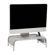 a computer monitor sitting on top of a metal stand with a pen and pencil in it