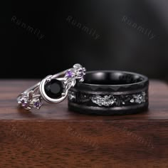 two wedding rings with amethorate and diamonds sitting on top of each other