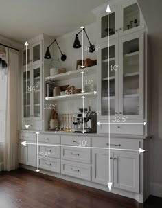 a kitchen with lots of white cabinets and numbers on the wall in front of it