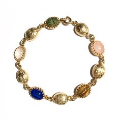 Finely detailed vintage gold gilt scarabs with hieroglyphs combine with vintage gemstone scarabs in this stunning dainty bracelet found only at Mas Collected. View all photos for close ups of the incredible detail. Makes a great gift idea for her!  Scarabs are considered to signify self transformation, new beginnings and good luck. Whether for you, or someone you love, welcome the season with our own in house designed limited quantity scarab gold filled bracelet!  Gemstone scarabs are hand set i Heirloom Gold Bracelets With Multi-stone, Heirloom Gold Multi-stone Bracelets, Vintage Yellow Gold Cabochon Bracelets, Antique Gold Bracelets With Cabochon, Antique Gold Cabochon Bracelets, Heirloom Gold Gemstone Bracelets, Gold Oval Bracelet With Gemstone Accents, Gold Oval Bracelets With Gemstone Accents, Oval Gold Bracelets With Gemstone Accents