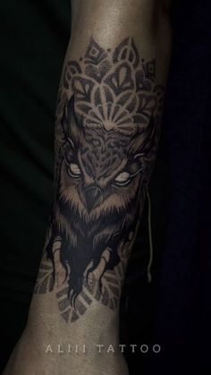 an owl tattoo on the arm and leg, with intricate details in black and grey