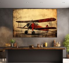 an old fashioned red airplane on display in a modern room with bar stools and potted plants