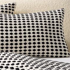 two black and white pillows sitting on top of a bed next to a pillow case