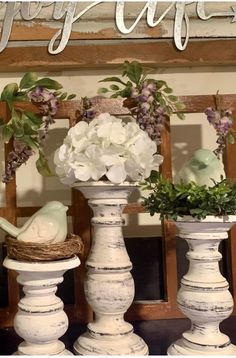 three white vases with flowers in them