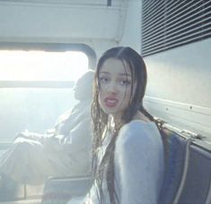 a woman with long hair sitting on a bus