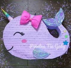 a paper plate with a unicorn horn and bow tie on it's head, surrounded by confetti sprinkles