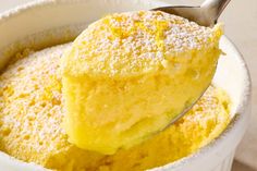 a scoop of lemon souffle with powdered sugar on top in a white bowl