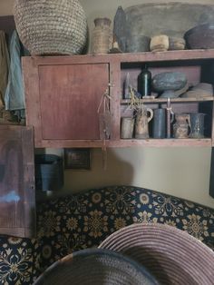 an old fashioned kitchen with pots and pans on the shelves