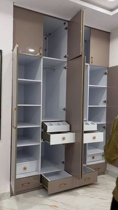 a man is walking past some closets with drawers