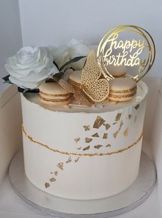 a birthday cake decorated with gold and white frosting