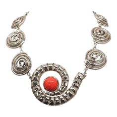 This is part of Chairish’s Costume Jewelry assortment.  1970s Modernist rhodium plated spiral links with cabochon faux-carnelian center and box clasp with a single clear round rhinestone on it necklace. Marked "U.C. Ugo Correani Made in Italy." Center:  2 inches long. Overall measures: 7 1/2 inches long by 5 1/2 inches wide. Interior circumference about 17 1/2 inches. Condition: Very good except that there is crazing to the metal coating on the clasp, which may be a problem at a later date, but Modern Spiral Jewelry For Formal Occasions, Modern Spiral Jewelry For Formal Events, Modern Spiral Metal Jewelry, Silver Spiral Jewelry For Party, Metal Cabochon Necklace In Costume Jewelry Style, Formal Metal Cabochon Jewelry, Formal Metal Jewelry With Cabochon, Silver Spiral Metal Necklaces, Silver Spiral Metal Necklace