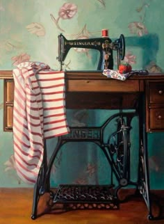 an old sewing machine sitting on top of a wooden table next to a striped towel