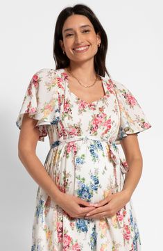 Perfect for a maternity photo shoot, this nursing-friendly midi dress is blooming with a colorful floral print that perfectly complements the fluttery sleeves. Stretchy shirred panels ensure a fit that grows with you, while discreet zippers allow easy access for nursing. Ties at back Sweetheart neck Short sleeves 51% cotton, 49% viscose Machine wash, line dry Imported Summer Dresses With Cape Sleeves And Floral Print, Summer Maternity Midi Dress With Floral Print, Spring Floral Print Maternity Dress, Short Sleeve Floral Maternity Dress, Flowy Floral Print Maternity Dress, Floral Print Short Sleeve Maternity Dress, Maternity Summer Dress With Flutter Sleeves, Summer Floral Maternity Dress For Garden Party, Spring Maternity Dress With Ruffles And Short Sleeves