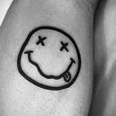 a black and white photo of a smiley face tattoo on the left calf's leg