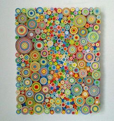 a painting made out of colorful circles on a white wall