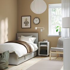 a bed room with a neatly made bed next to a night stand and a window