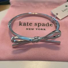 Kate Spade Skinny Mini Bow Silver-Toned Hinged Bracelet Bangle Bracelet With Large Bow And Hinged Closure In Silver-Toned Metal 2.5" Diameter Imported Dust Bag Included Kate Spade, Known For Her Sophisticated And Feminine Designs, Presents This Sweet Skinny Mini Bow Bangle Bracelet Perfect For Adding A Touch Of Playfulness To A Look. New With Tags. Comes With Pink Dust Bag For Gifting! Clean, Smoke-Free, Pet Loving Home Bracelets To Make, Kate Spade Outlet, Mini Bow, Jewelry Accessories Ideas, Dope Jewelry, Mini Bows, Girly Accessories, Hinged Bracelet, Funky Jewelry