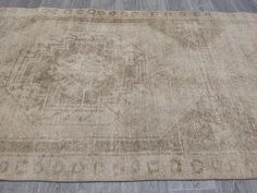 an antique rug is on the floor with wood floors