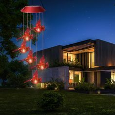 a house is lit up at night with red flowers hanging from it's roof