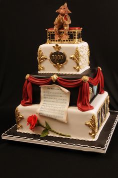 a three tiered cake decorated with musical notes and a statue of a man on top