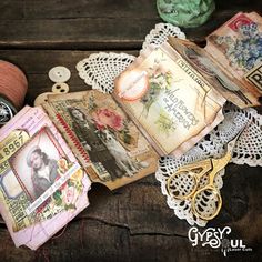 an assortment of crafting items are laid out on a wooden table with lace, scissors and thread