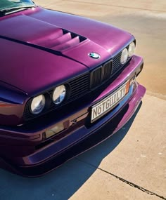 the front end of a purple car parked in a parking lot