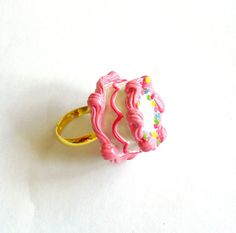 Mini Pink Birthday Cake Ring - Miniature Food Jewelry This adjustable ring features a beautifully detailed pink birthday cake. This tiny little cake was inspired by the classic little girls birthday cake. A round cake frosted with vanilla buttercream and piped pink buttercream edges, Pink Novelty Jewelry For Birthday, Cute Pink Round Rings, Cute Pink Jewelry For Birthday, Playful Pink Rings For Gifts, Playful Pink Rings Perfect For Gifts, Playful Pink Rings As A Gift, Cute Pink Party Rings, Cute Pink Rings For Parties, Sweet Pink Jewelry For Birthday Gift