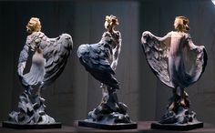 three sculptures of birds are on display together