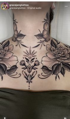 a woman's neck with flowers and leaves on the back of her chest,