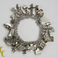 Sterling Silver Charm Bracelet With 35 Various Charms Total Mass = 96.0 Grams .925 Sterling Silver Chain Measuring 7" Long 35 Unique Charms From All Over The Us Please See Photos For Details And Message Us With Any Questions. Formal White Gold Metal Charm Bracelet, Elegant Metal Charm Bracelet Collectible, Elegant Metal Charm Bracelet For Collectors, Formal White Gold Charm Bracelets, Formal White Gold Bracelets With Charms, Silver Charm Bracelet For Formal Occasions, Elegant Hallmarked Charm Bracelet, Silver Luxury Charm Bracelet With Polished Finish, Luxury Silver Charm Bracelet With Polished Finish