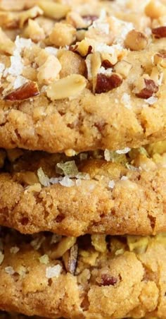 three cookies stacked on top of each other with nuts and coconut flakes all over them