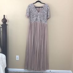 This Maya Deluxe Blush Maxi Dress Is A Beautiful Dress Perfect For A Wedding. Empire Waist.Vneck. Sequin Top. Short Sleeves. Tulle Bottom With Lining. New With Tags. Size 12. 100% Polyester. Length: 60in. Bust: 18in. Arm Length: 8in. Short Sleeve Sequined Maxi Dress For Wedding, Elegant Silver Bridesmaid Dress, Glamorous Short Sleeve Maxi Dress For Wedding, Glamorous V-neck Dress For Mother Of The Bride, Silver Spring Wedding Maxi Dress, Spring Wedding Silver Maxi Dress, Silver Floor-length Dress For Mother Of The Bride, Silver V-neck Evening Dress For Wedding, Spring Wedding Mother Of The Bride Dress With Sequins