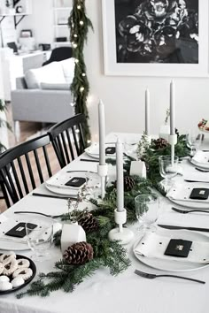 the table is set with candles, plates and place settings for christmas dinner guests to enjoy