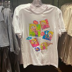 a t - shirt with cartoon characters is hanging on a rack