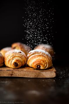 croissants sprinkled with powder on a cutting board