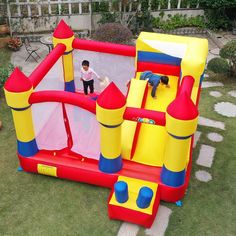 an inflatable bounce house with a little boy standing on the top one side