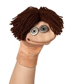 a hand holding up a puppet with eyes on it