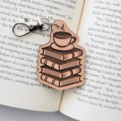 a wooden keychain with a stack of books and a cup of coffee on it